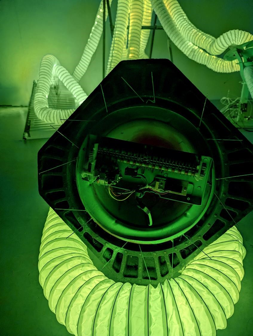 Green-lit tube and mechanical forms.