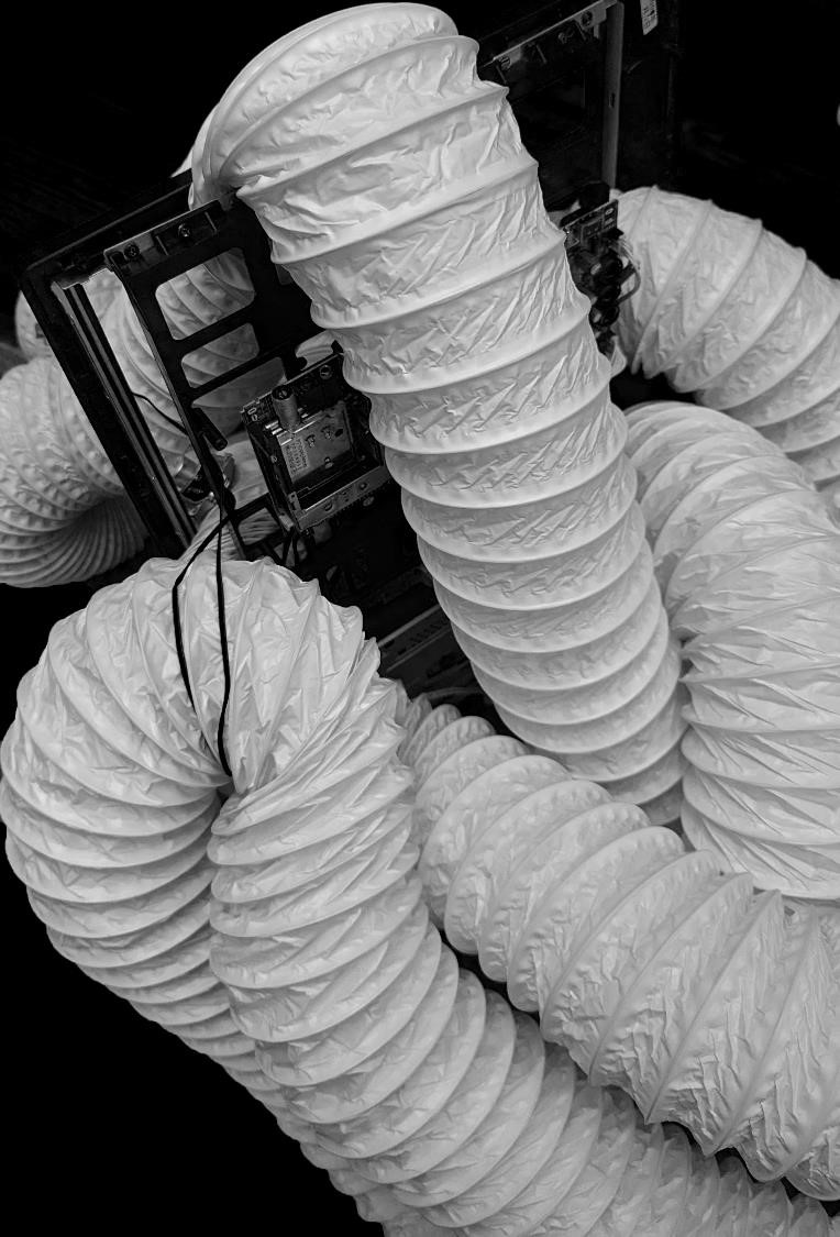 Black and white photo of tubing crawling over a computer monitor frame.
