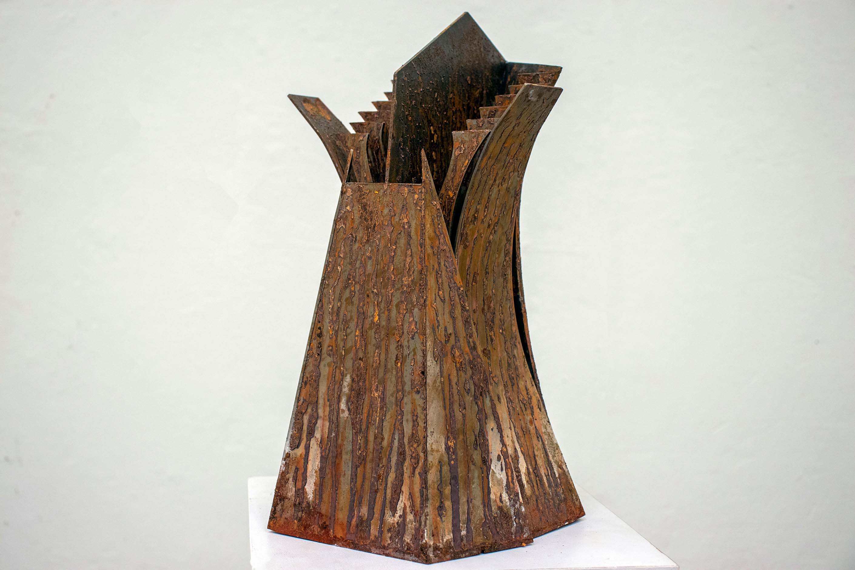 rusted steel sculpture on white plinth