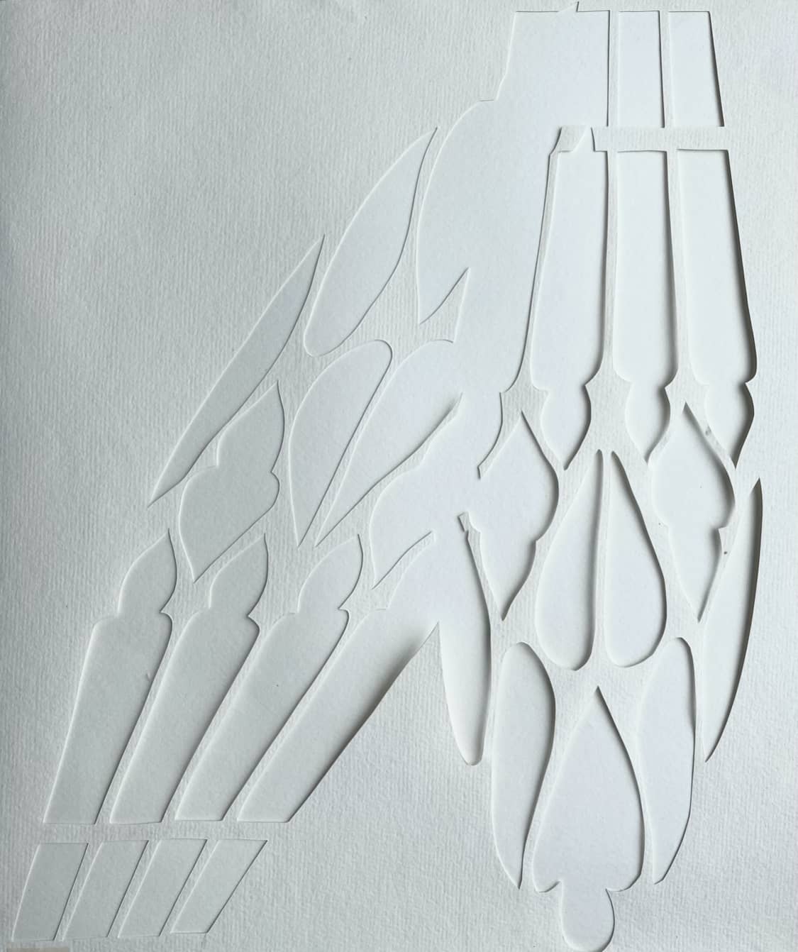 a paper cut out showing two overlapped and stretched gothic window shades intersecting