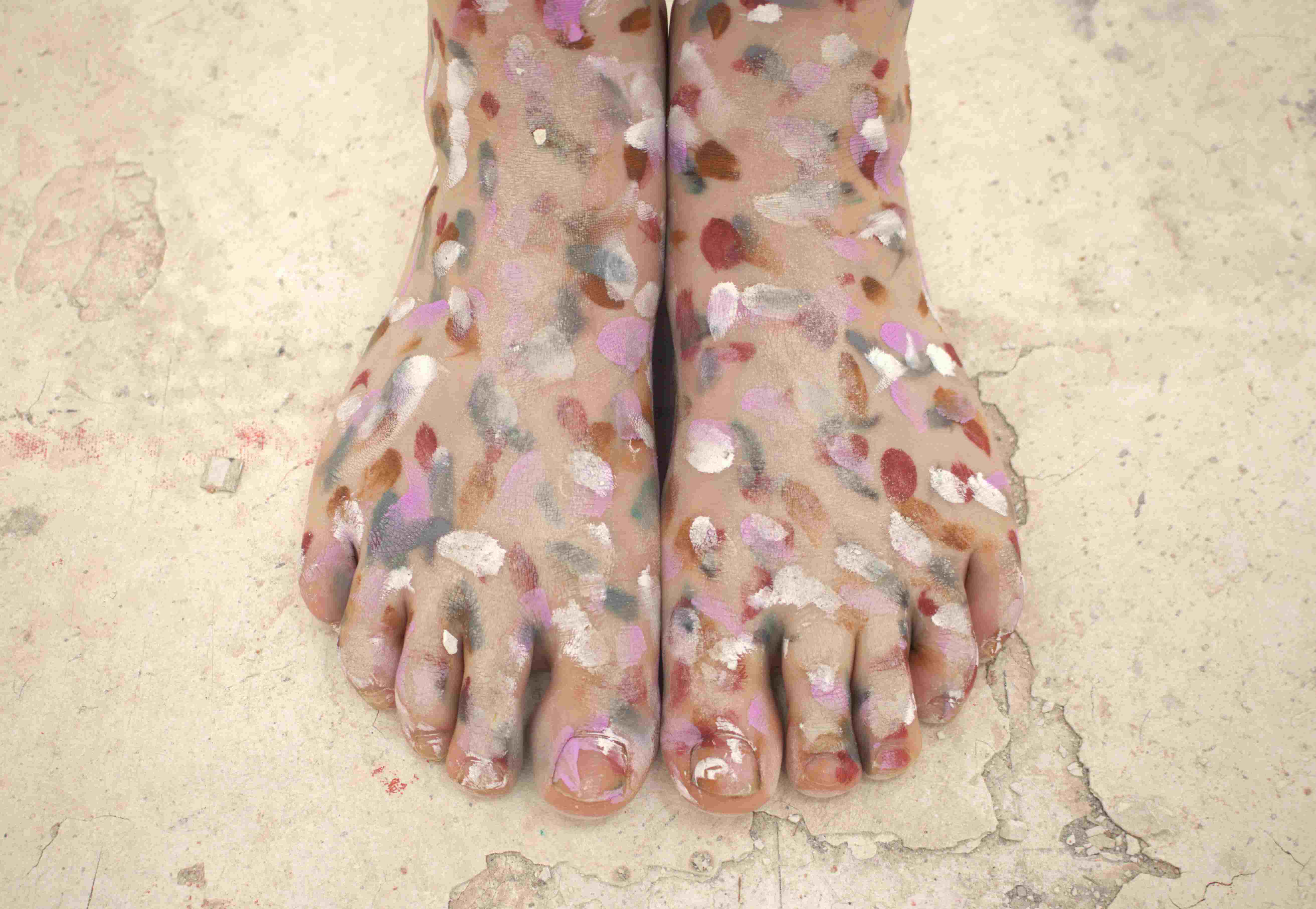 feet on a dirty white floor, painted in brown, pink and grey shades