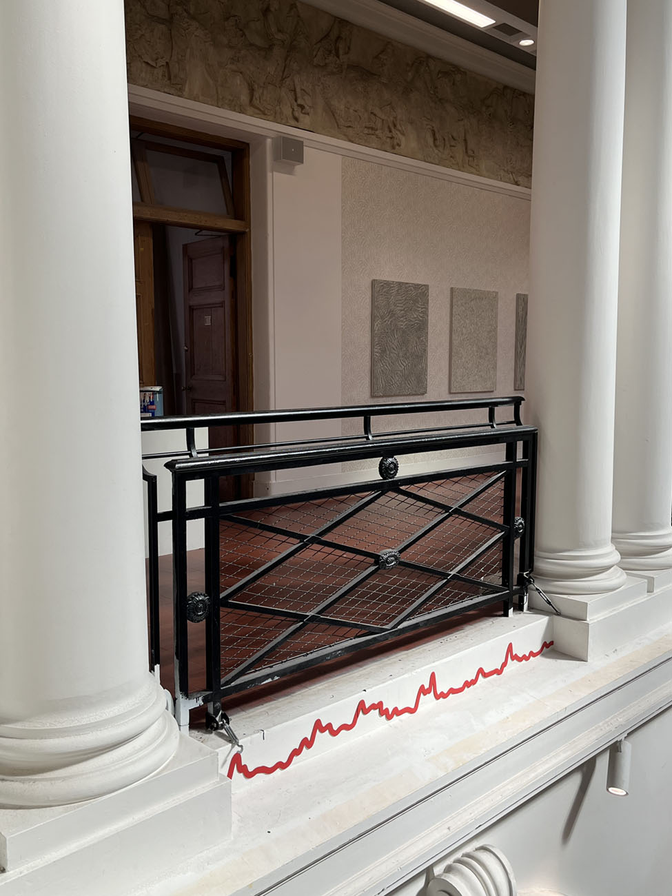 Thin red line along sculpture court balcony.