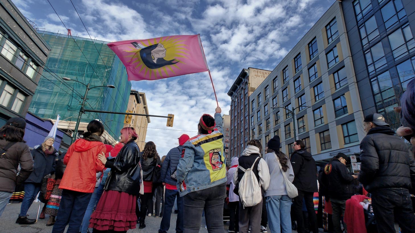 Women waving pink memorial flag above her head at a march 