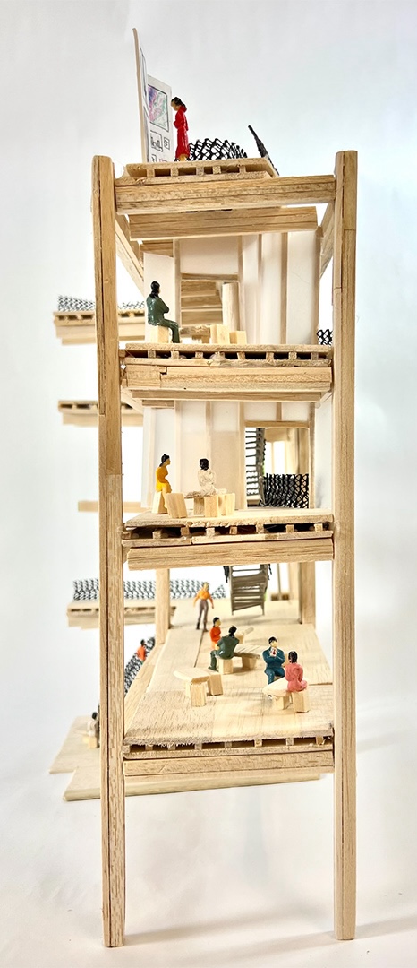 A photo of the 1:50 fragment model's social spaces, showing floors, people on them, and the frame.