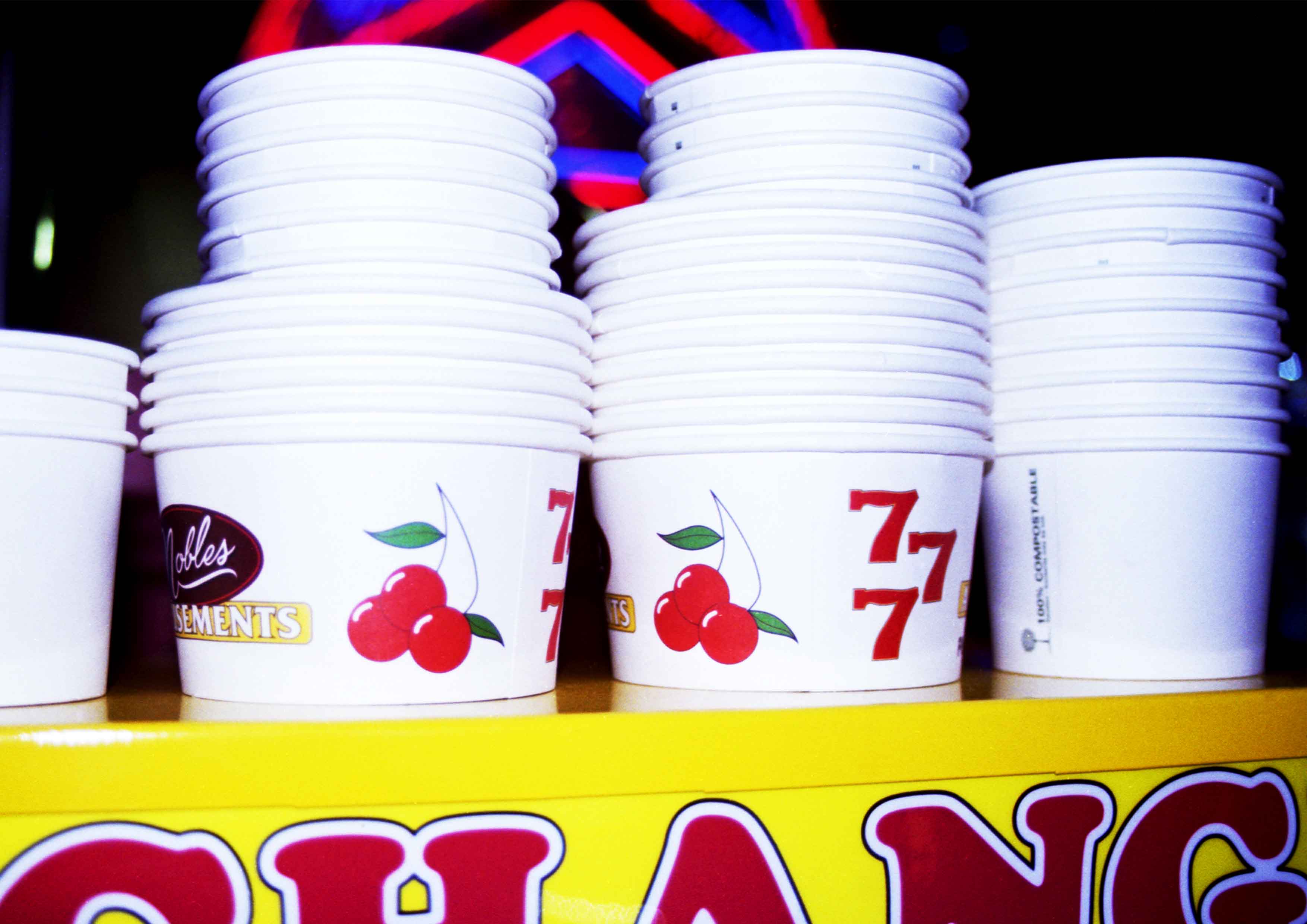The image captures the top of an arcade change machine which multiple, repetitive stacked penny tubs with graphic cartoons and shapes. 