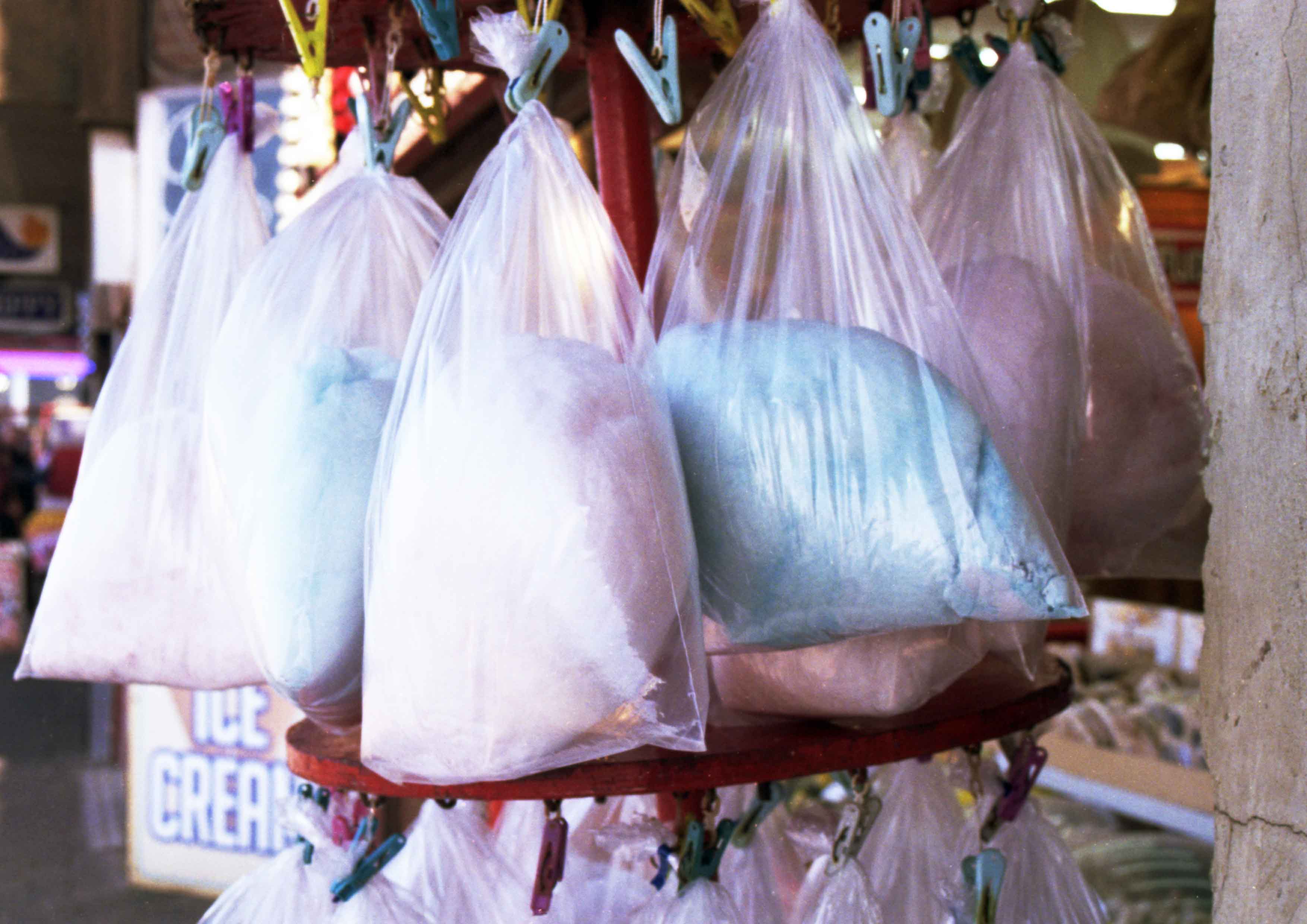 The image captures a collection of blue and pink candy floss in plastic bags 