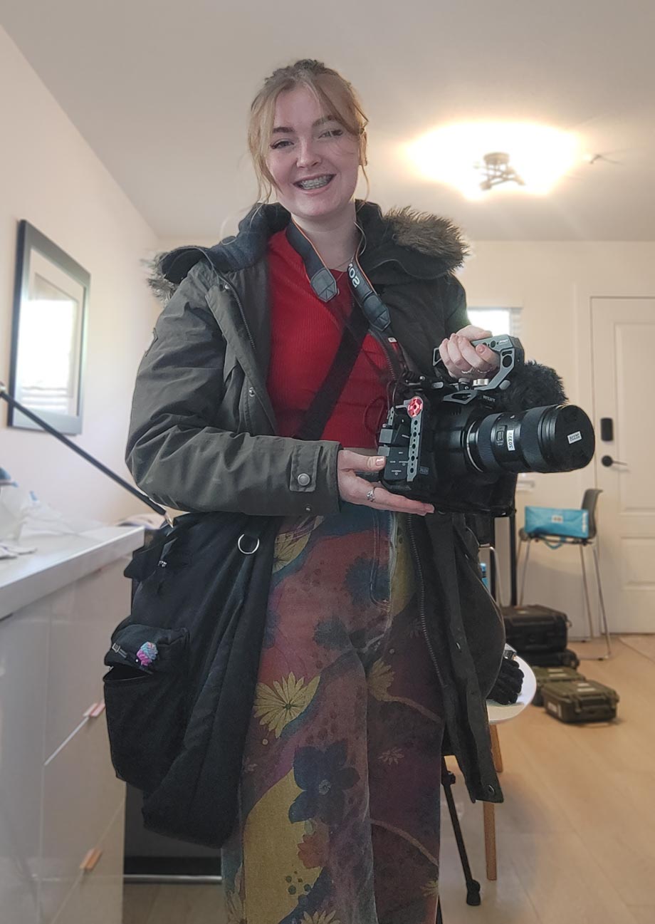 Women smiling holding cinema camera 