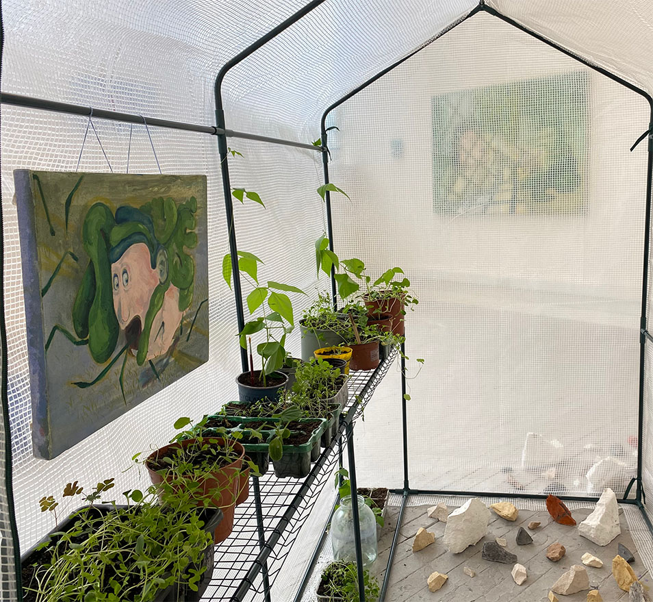 Spiked painting hanging in a greenhouse full of plants in a white cube space