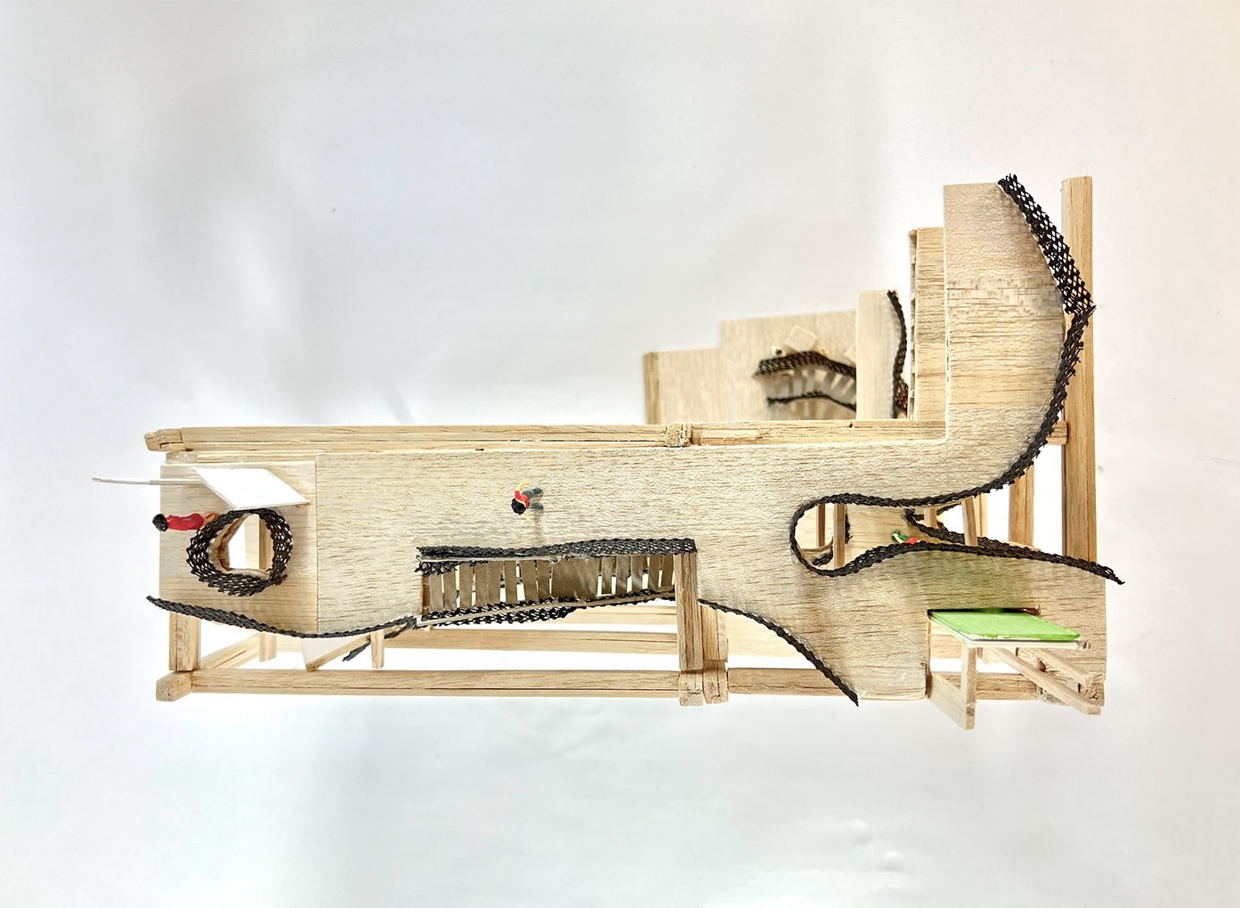 A photo of the 1:50 fragment model looking directly down onto the fourth floor, showing the floor's shape, wooden floor, and balustrades.
