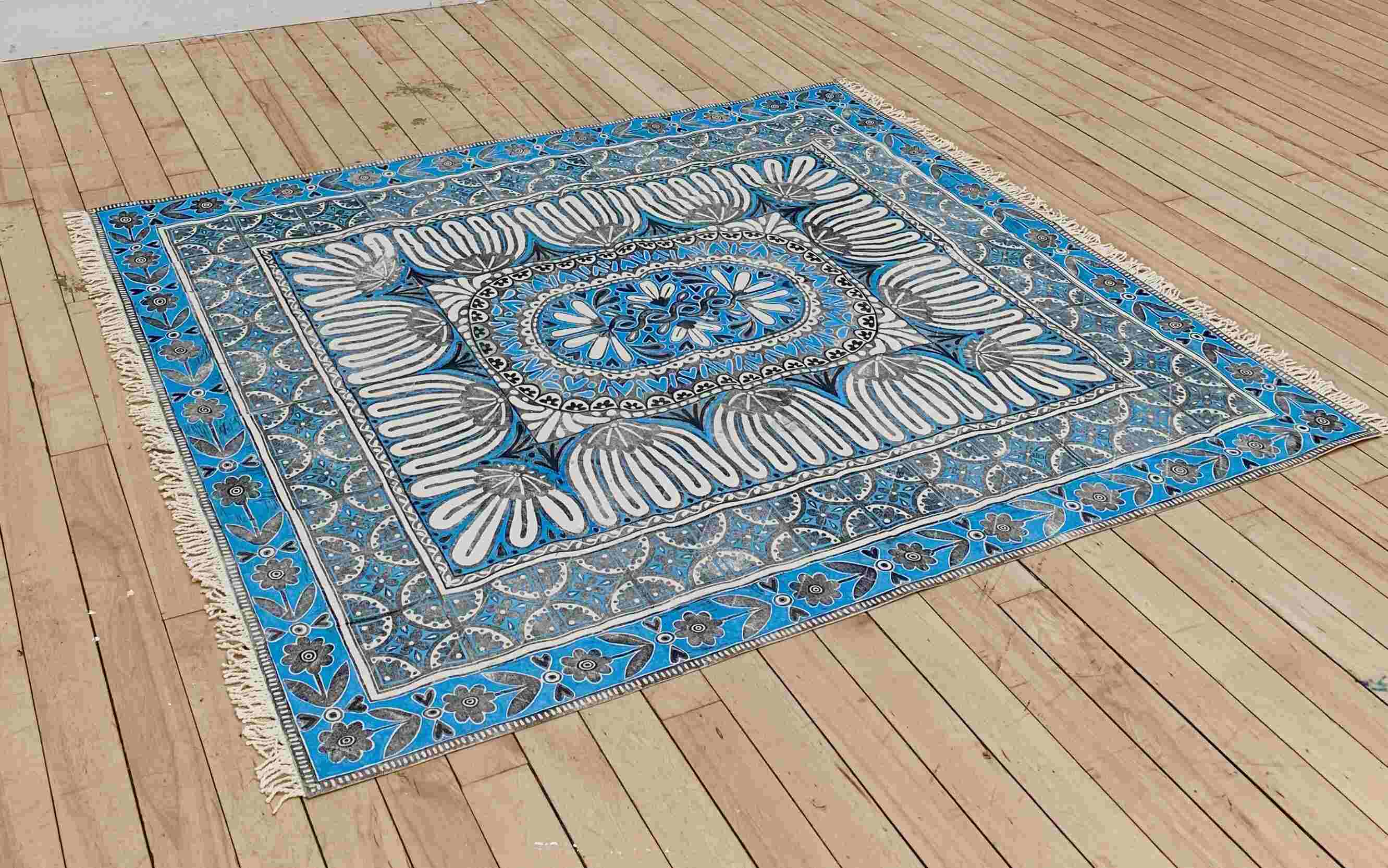 blue, white and black lino printed rug on floor
