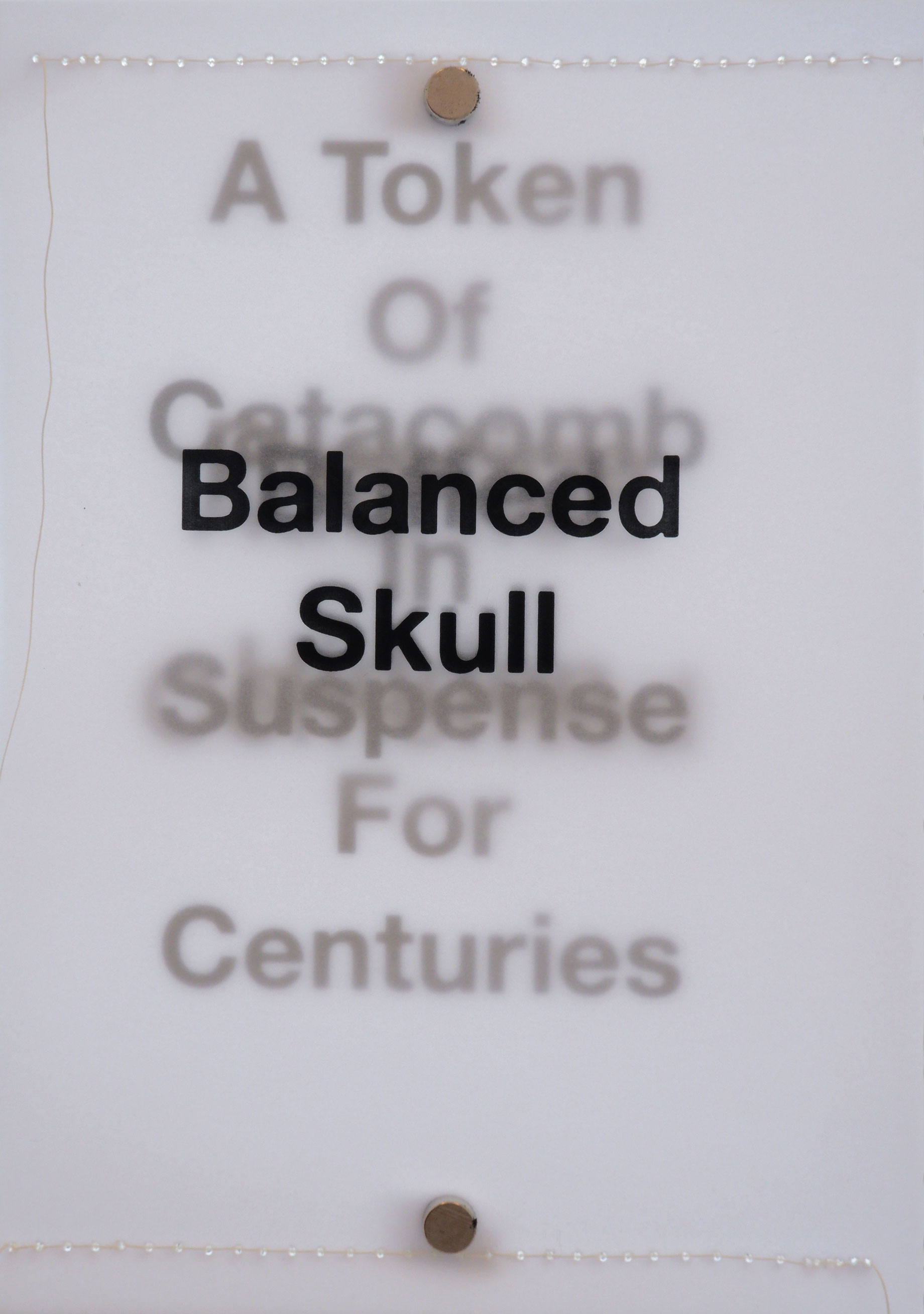 Layers of black text backlit on tracing paper with white stitching along short sides