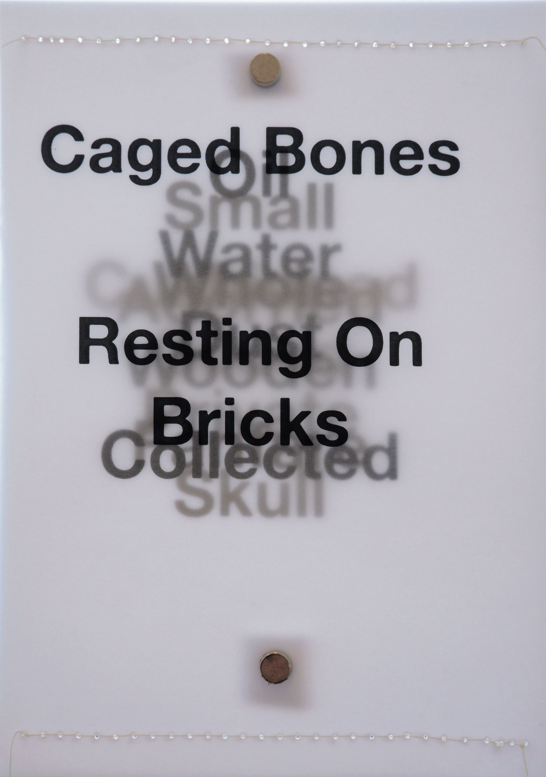 Layers of black text backlit on tracing paper with white stitching along short sides