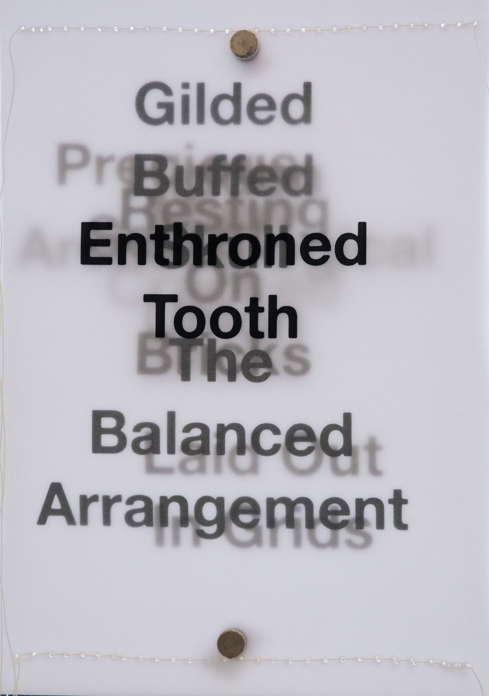 Layers of black text backlit on tracing paper with white stitching along short sides