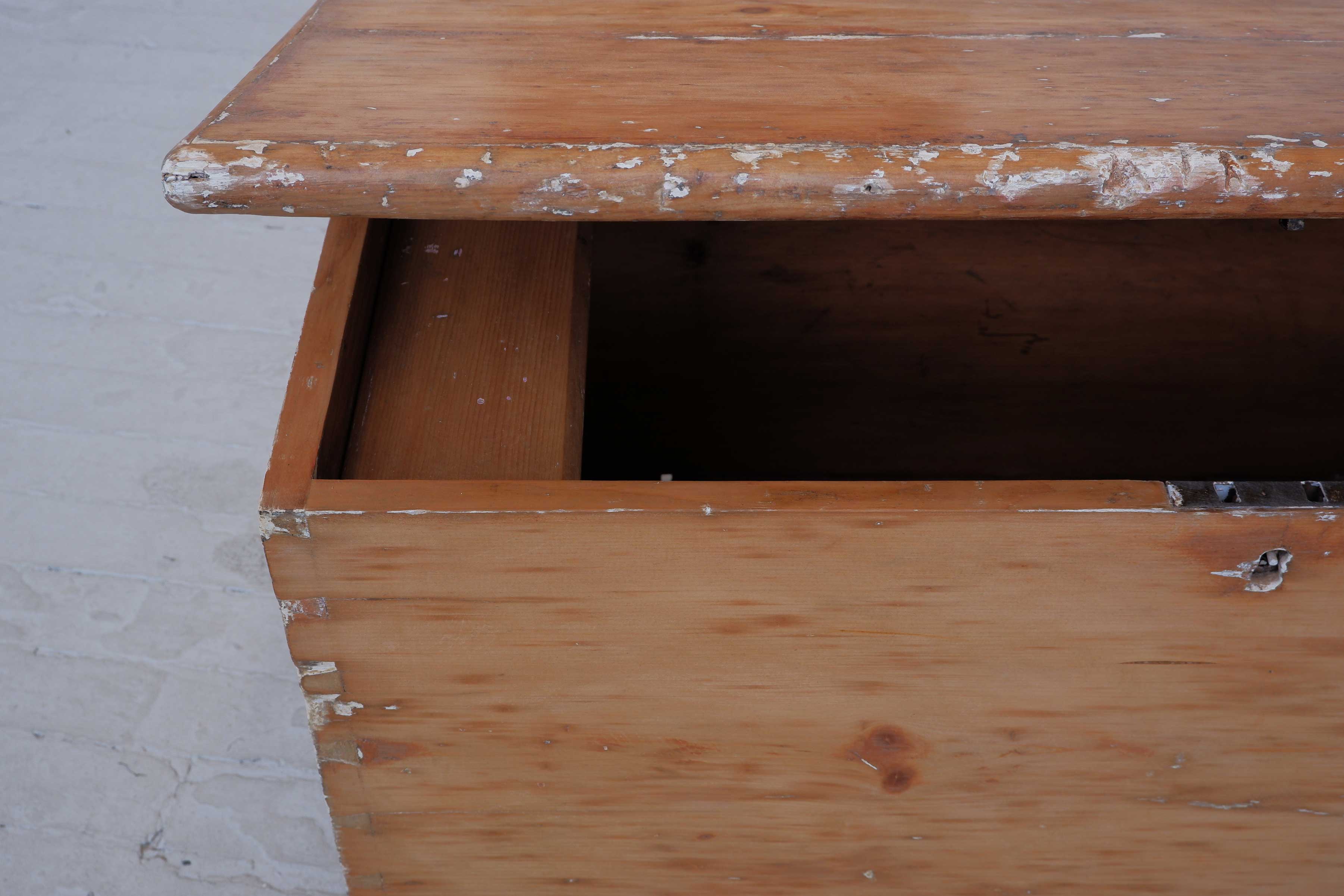 A wooden kist, the lid of which is propped open.