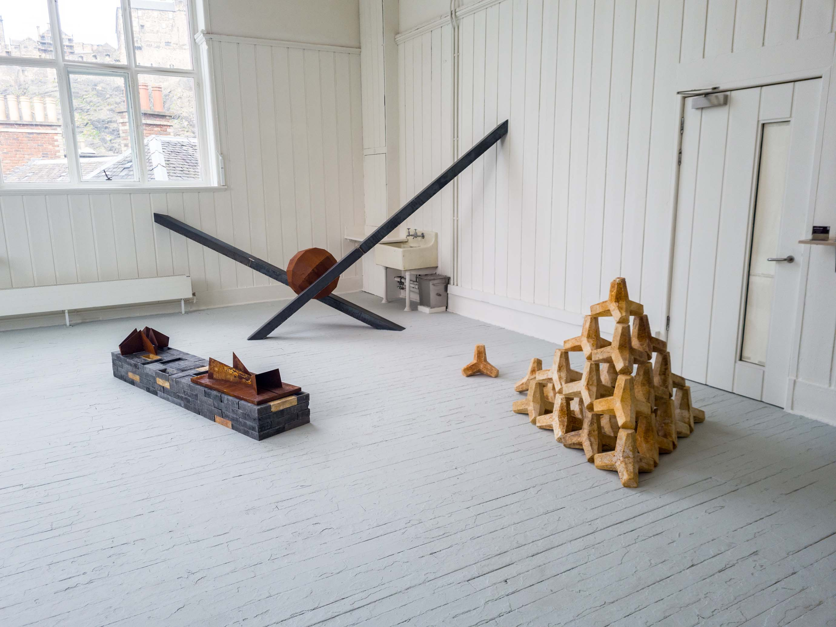 Degree show space showcasing steel sculptures and plaster casts, taken from front