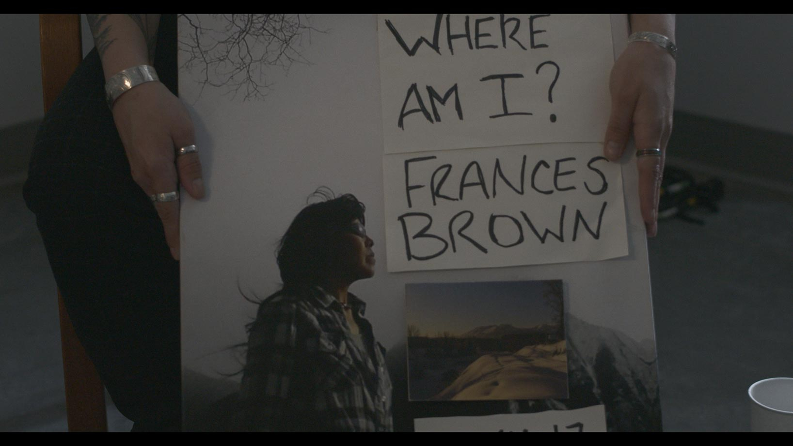 Hands holding canvas of missing person poster 