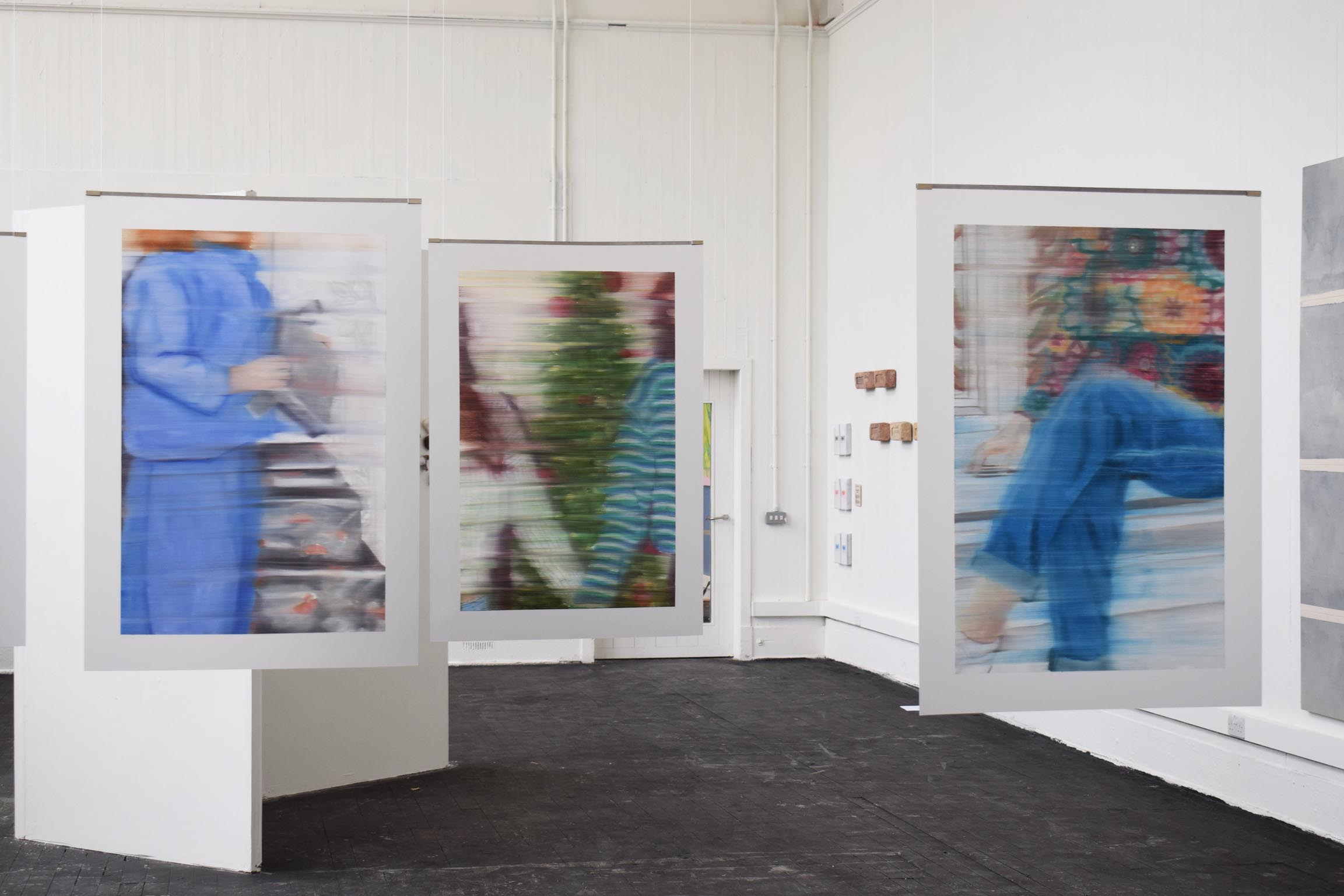 3 paintings installed in the centre of a room. 