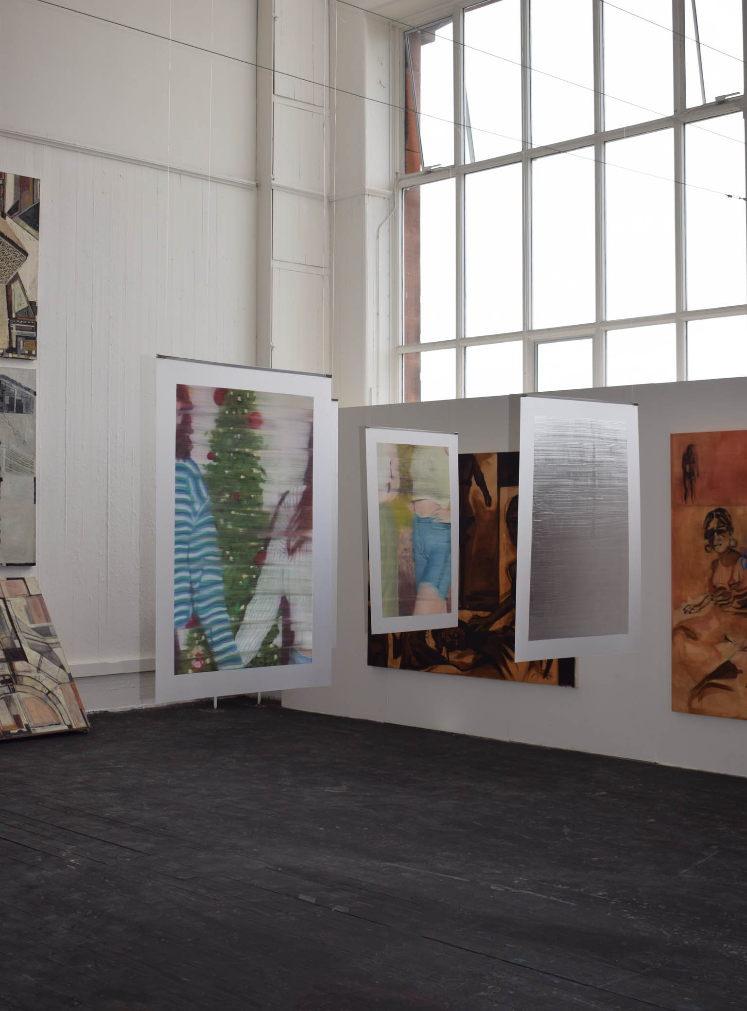 3 paintings hanging in the centre of a room. 