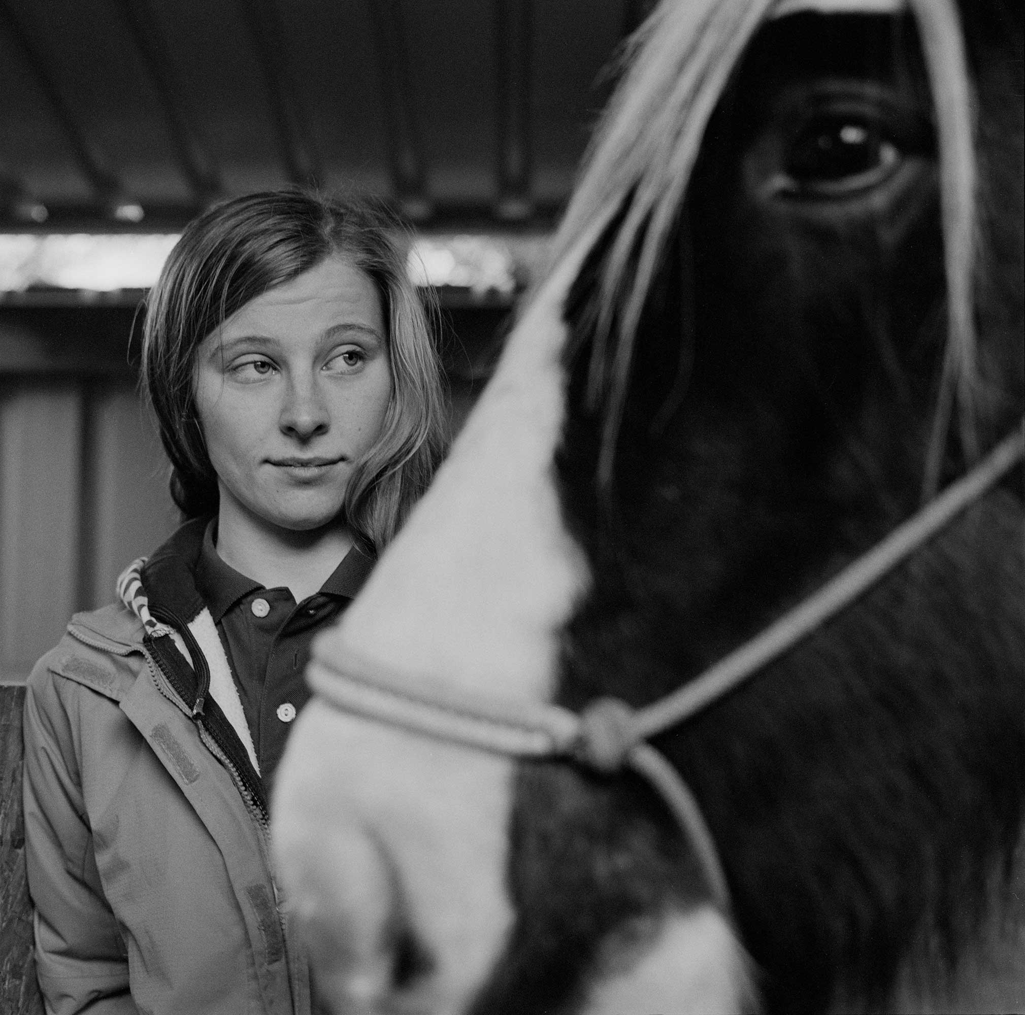 Girl stood behind a horse