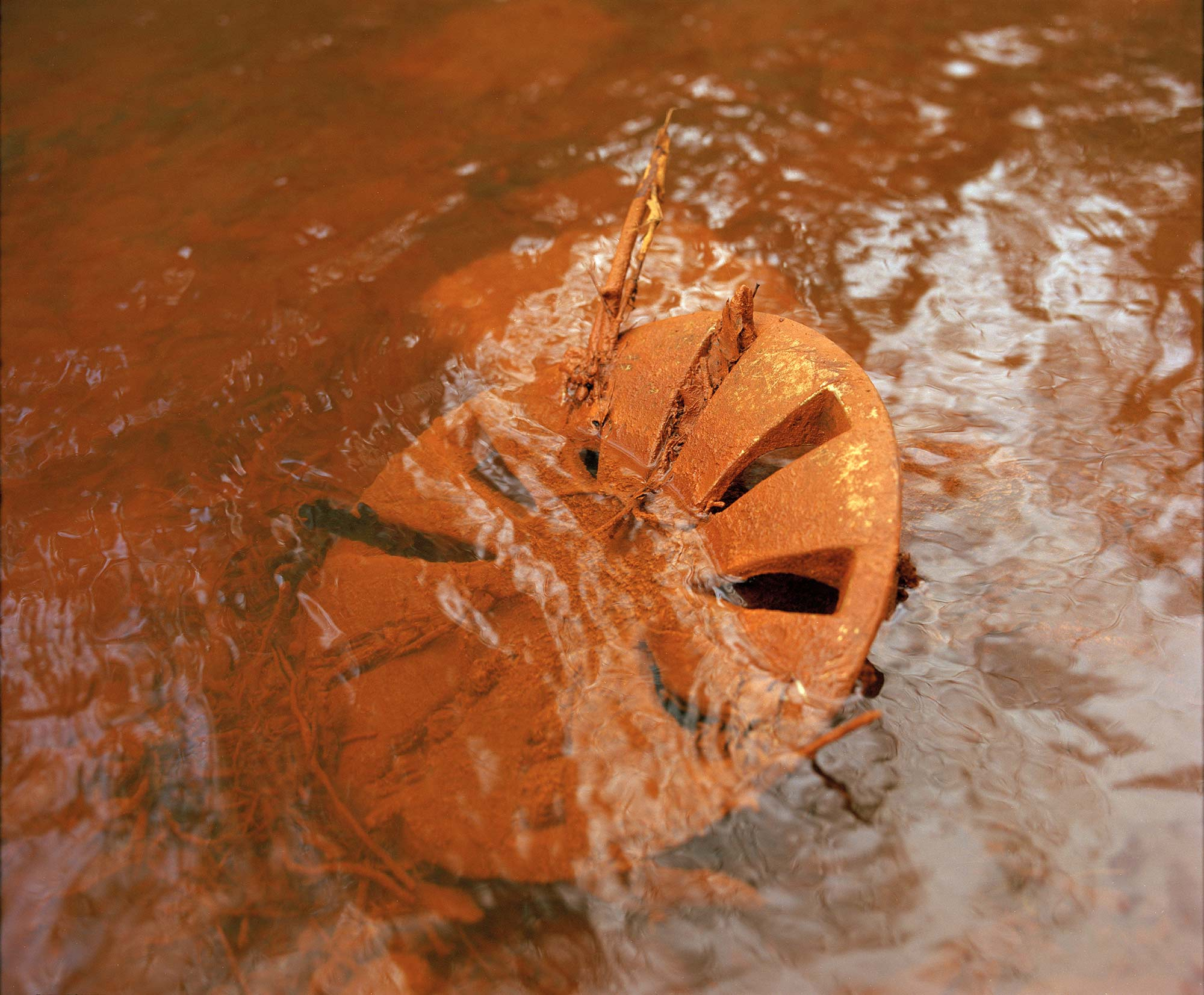 Hub cap covered in iron oxide submerged underwater