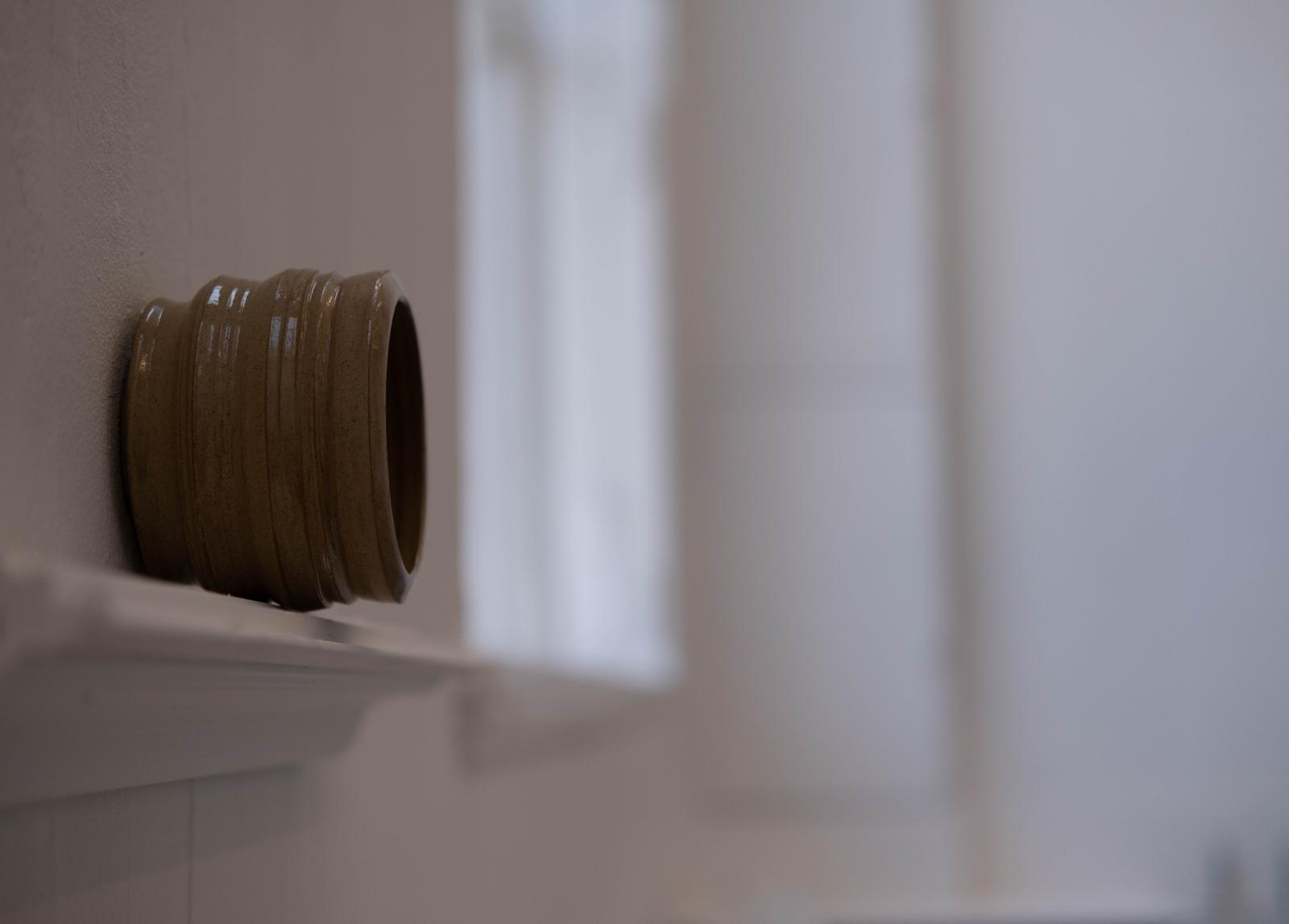 Ceramic cylinder with transparent glaze.