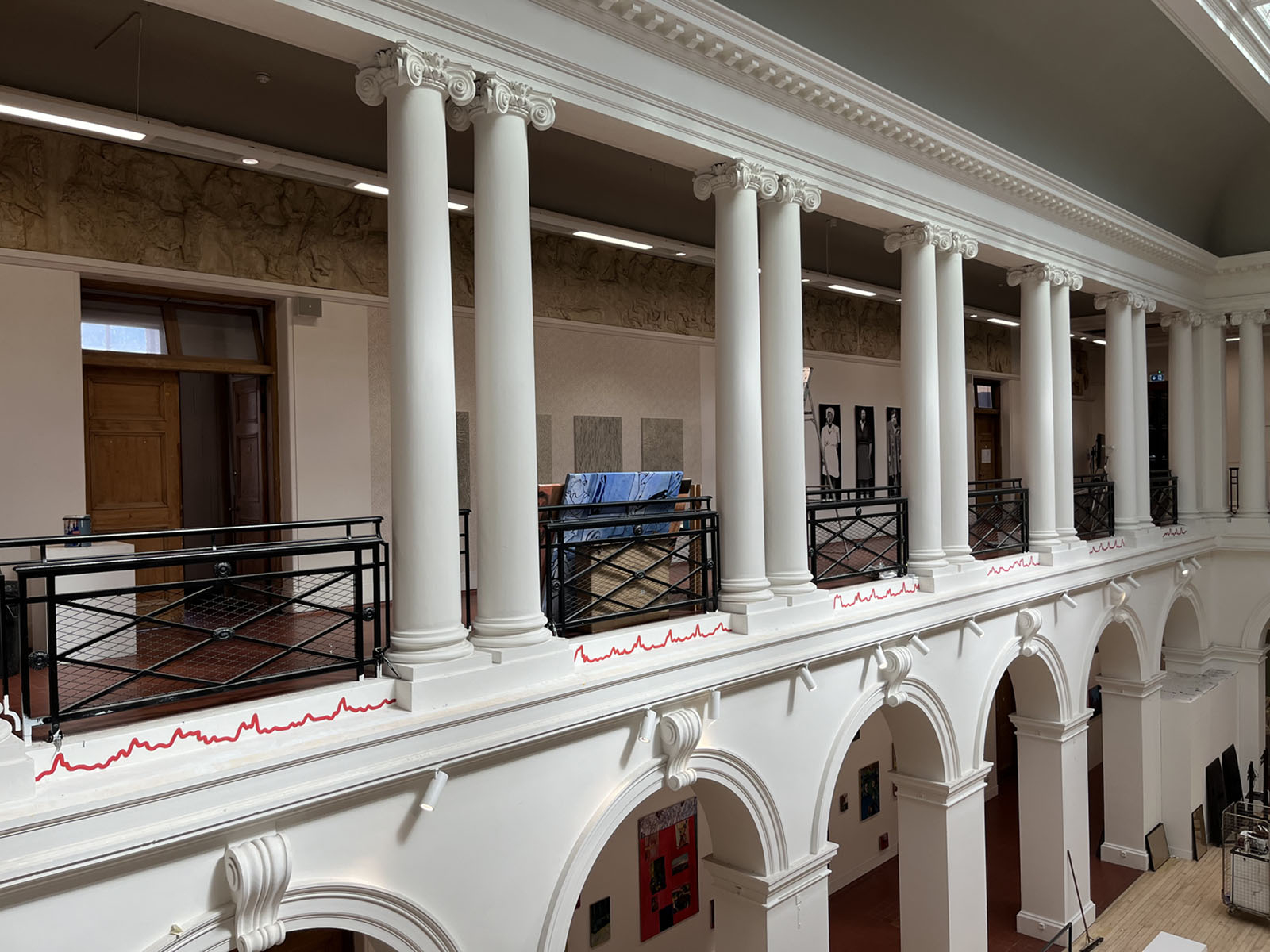 Thin red line along sculpture court balcony.