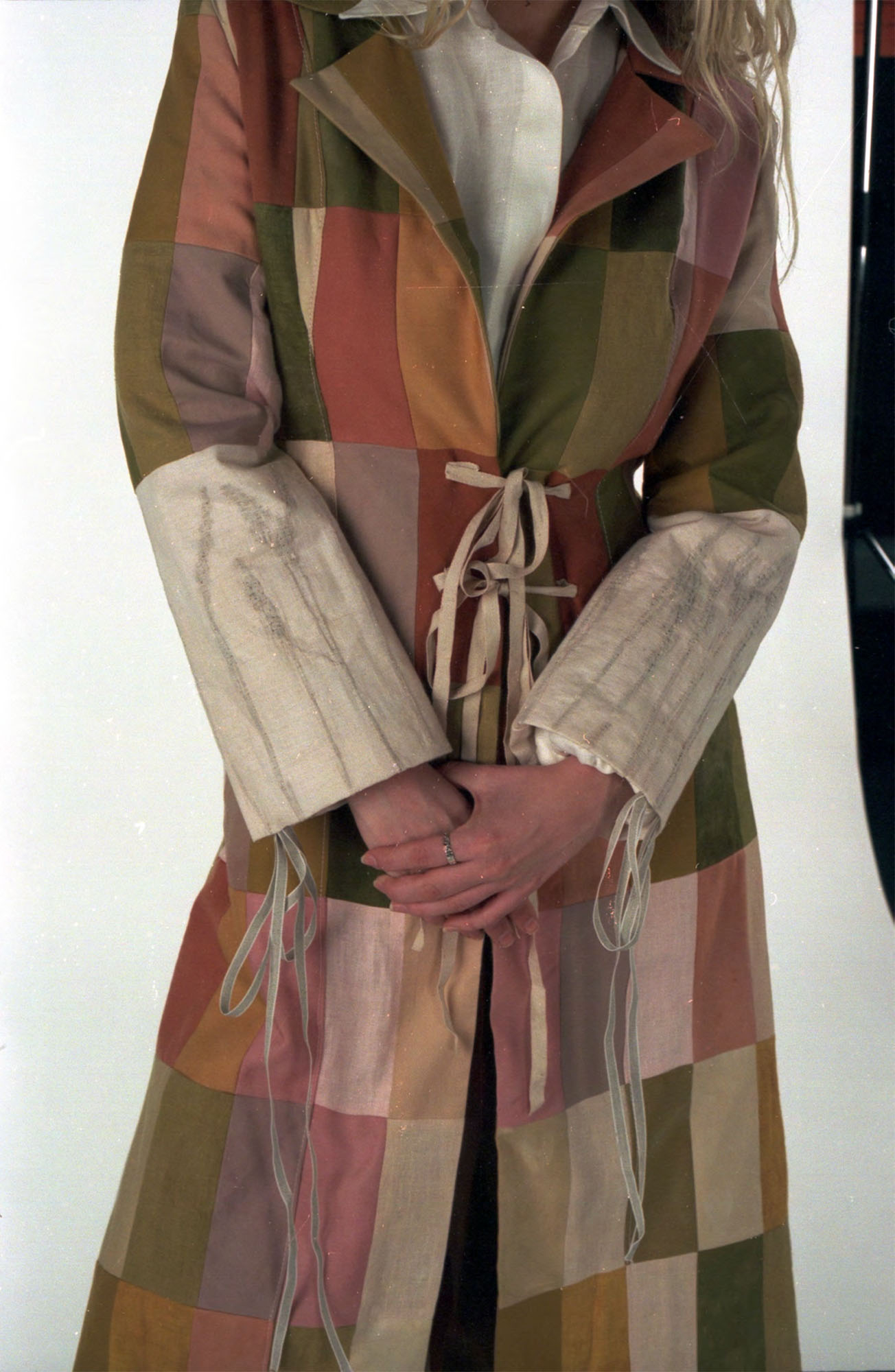 Patchwork coat made up of dyed fabric scraps of linen, wool and cotton, with reeds embedded in the sleeves.