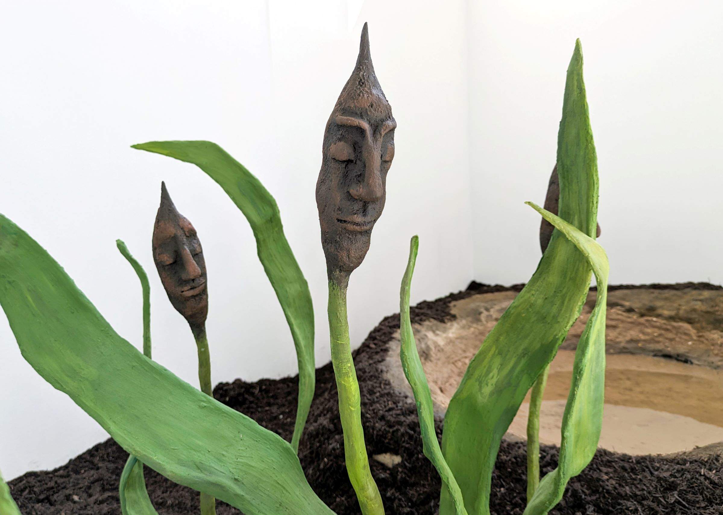 Two bullrushes with human faces
