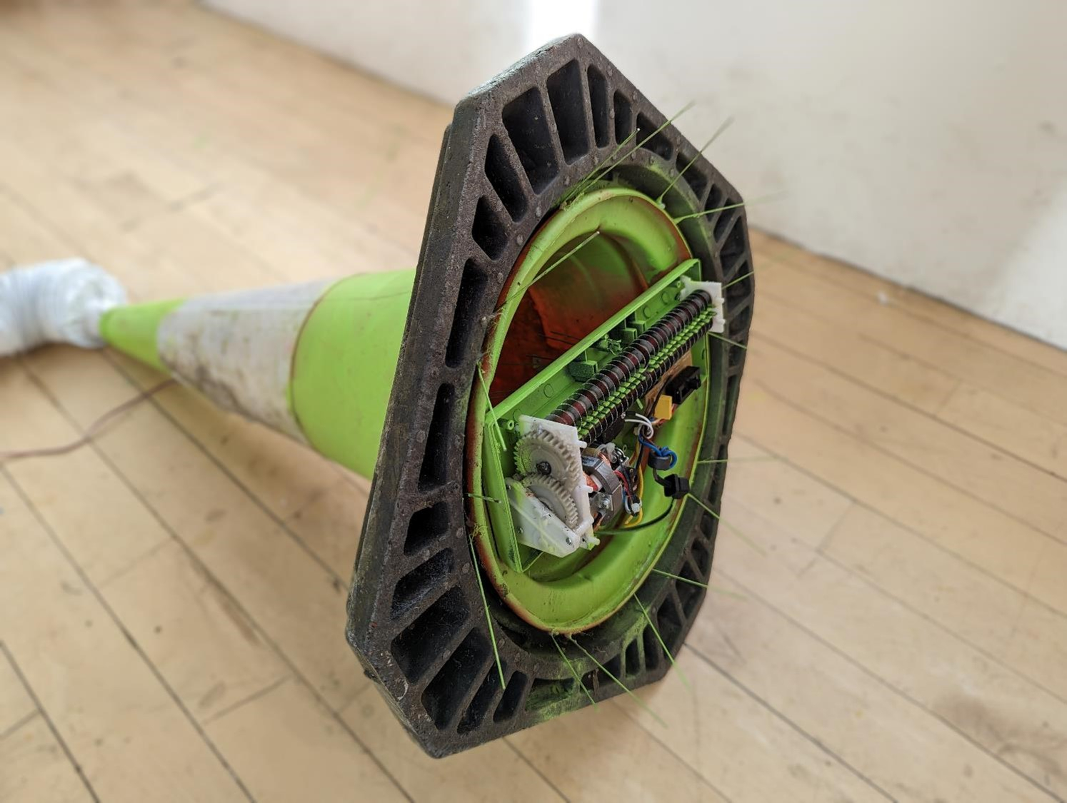 Sculpture made of a paper shredder and a traffic cone, sprayed green