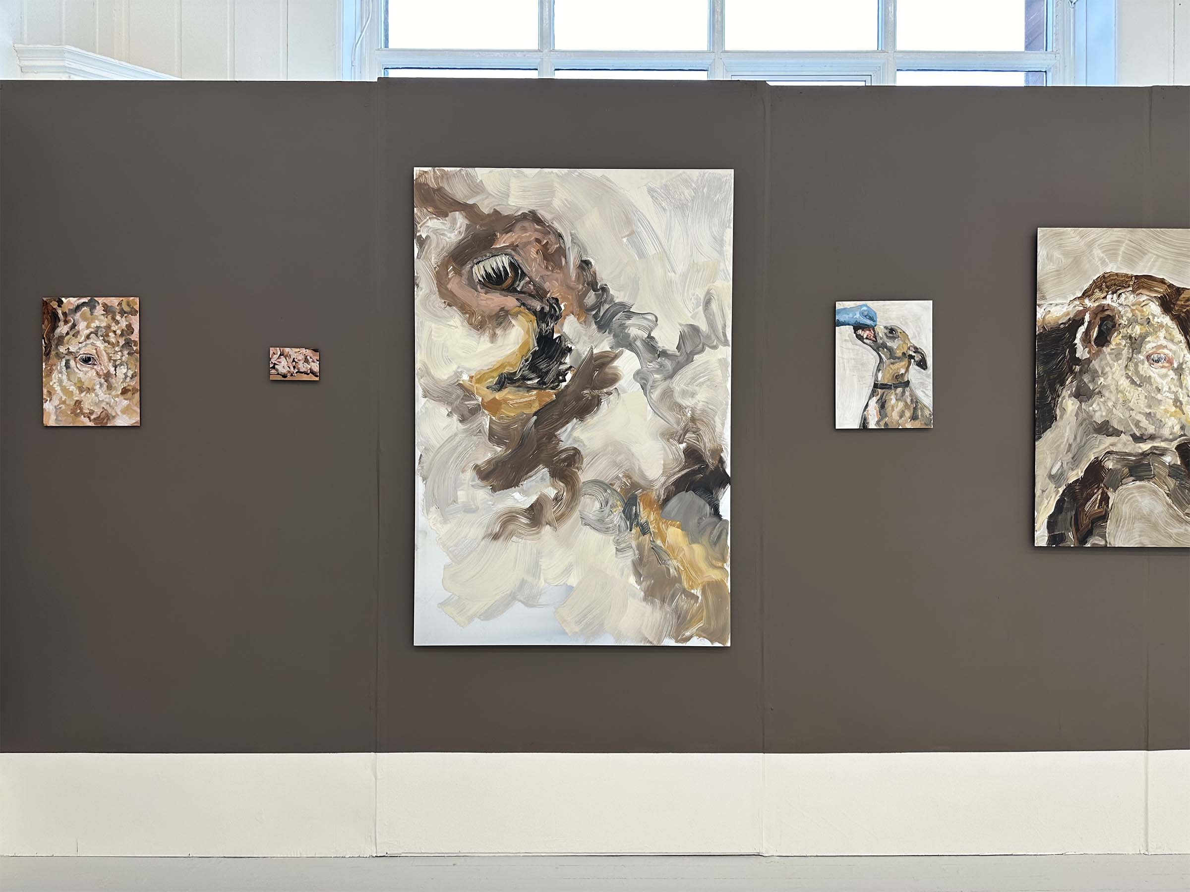 various paintings on metal panels on a brown wall