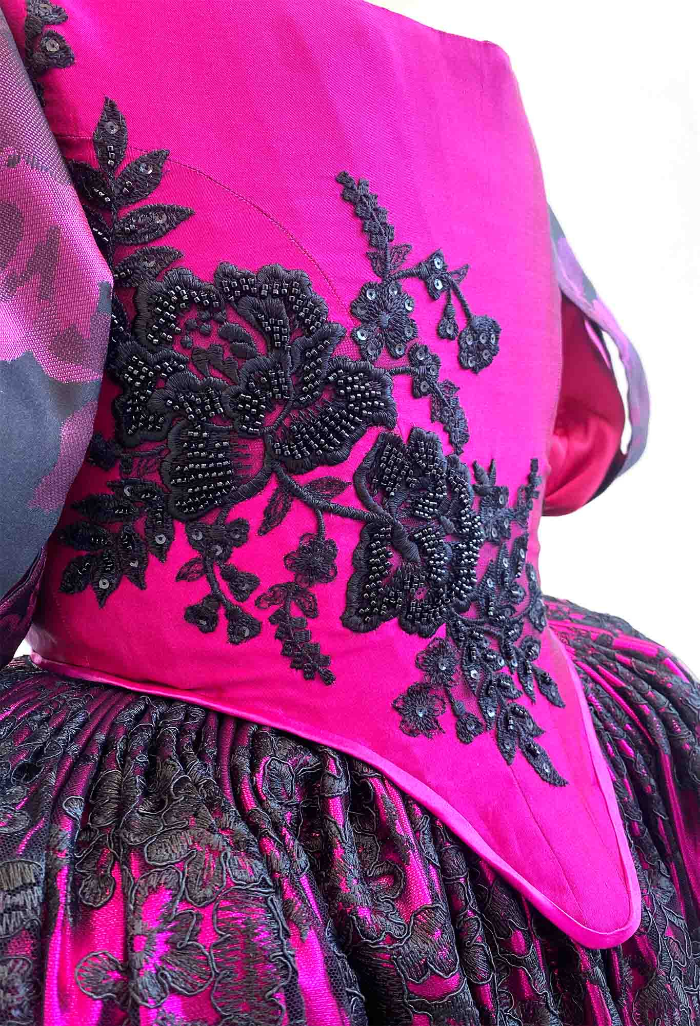 closeup shot of a historical pink bodice with black floral bead applique