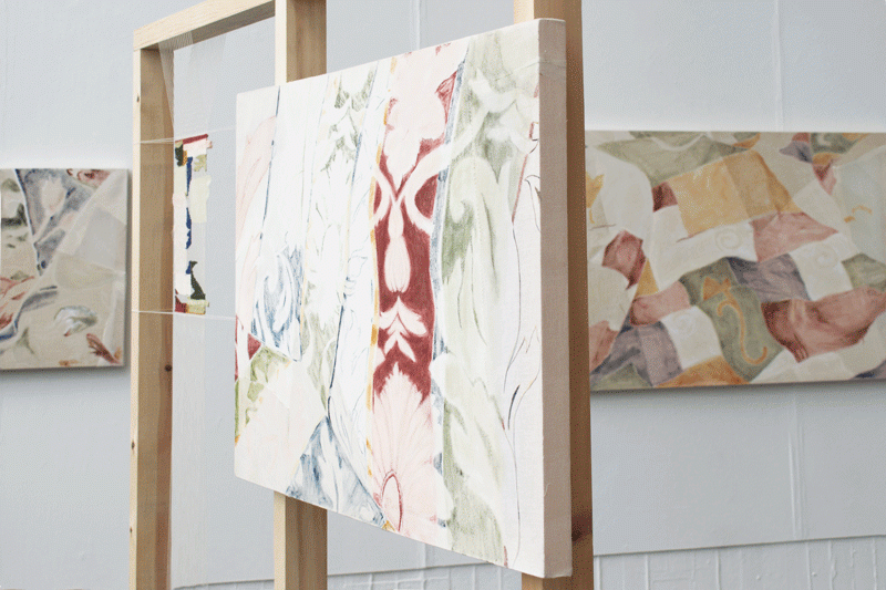 painting on wooden structure next to weaving, paintings in background