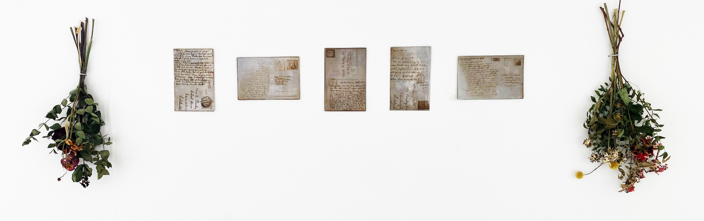 five metal engraved postcards with dried flowers either side