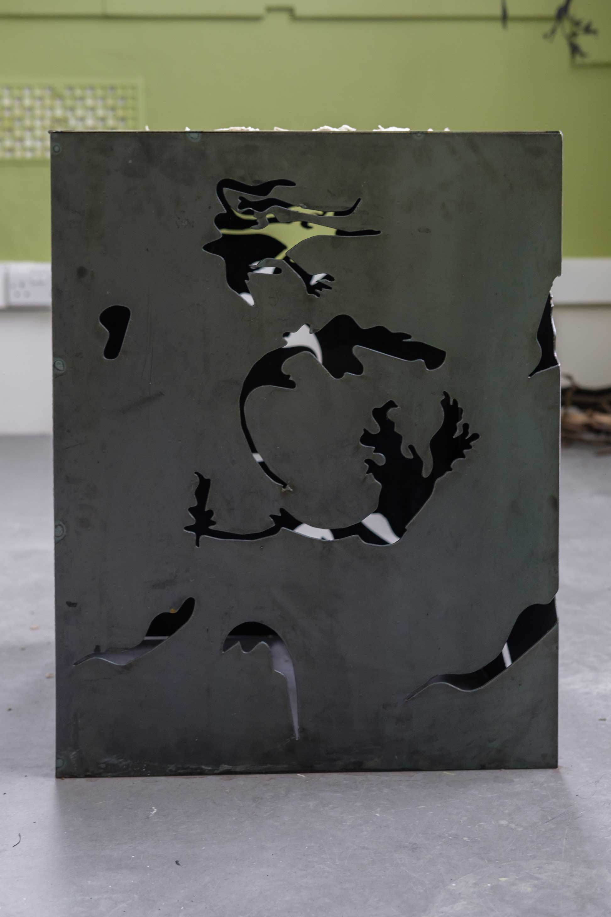 Mild weld steel cube structure, with organic leaf and flower shapes cut out.