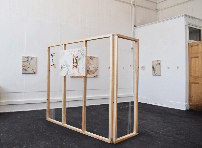 wooden structure in white space, colourful paintings on wall 