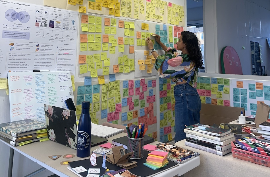 Workspace with a woman working in a wall full of post-its
